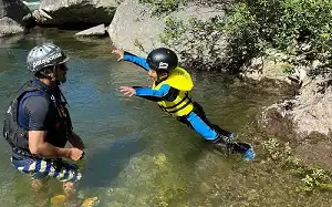水上(みなかみ)ウォーターアドベンチャ, kid jumping from the cliff enjoying minakami water adventure, 岩壁からジャンプしながら水上(みなかみ)ウォーターアドベンチャーを楽しんでいる子供